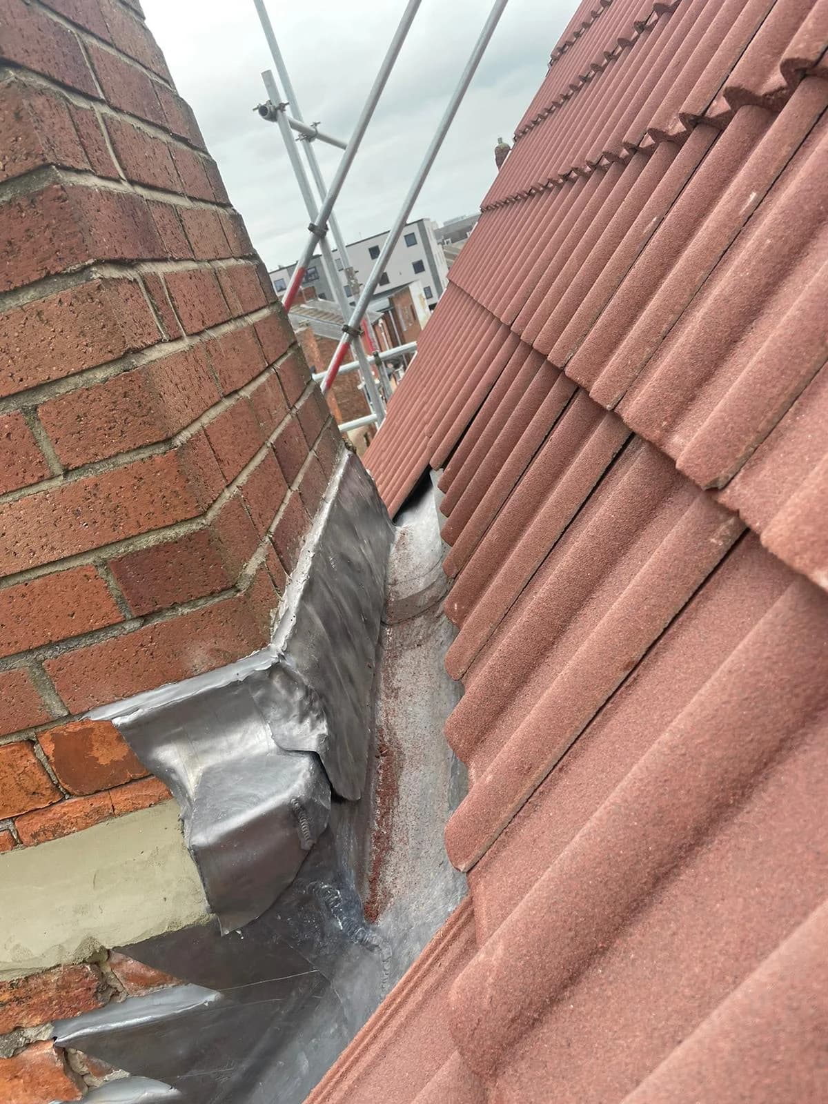 Completed slate pitched roof catching low sunlight in County Durham