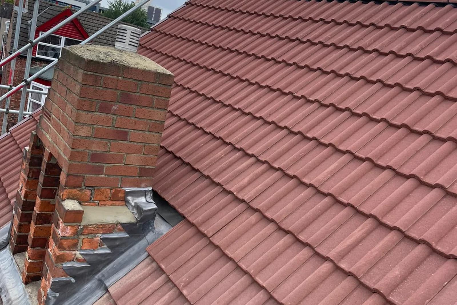 Repaired tiled roof with a rebuilt chimney and new lead flashing in County Durham